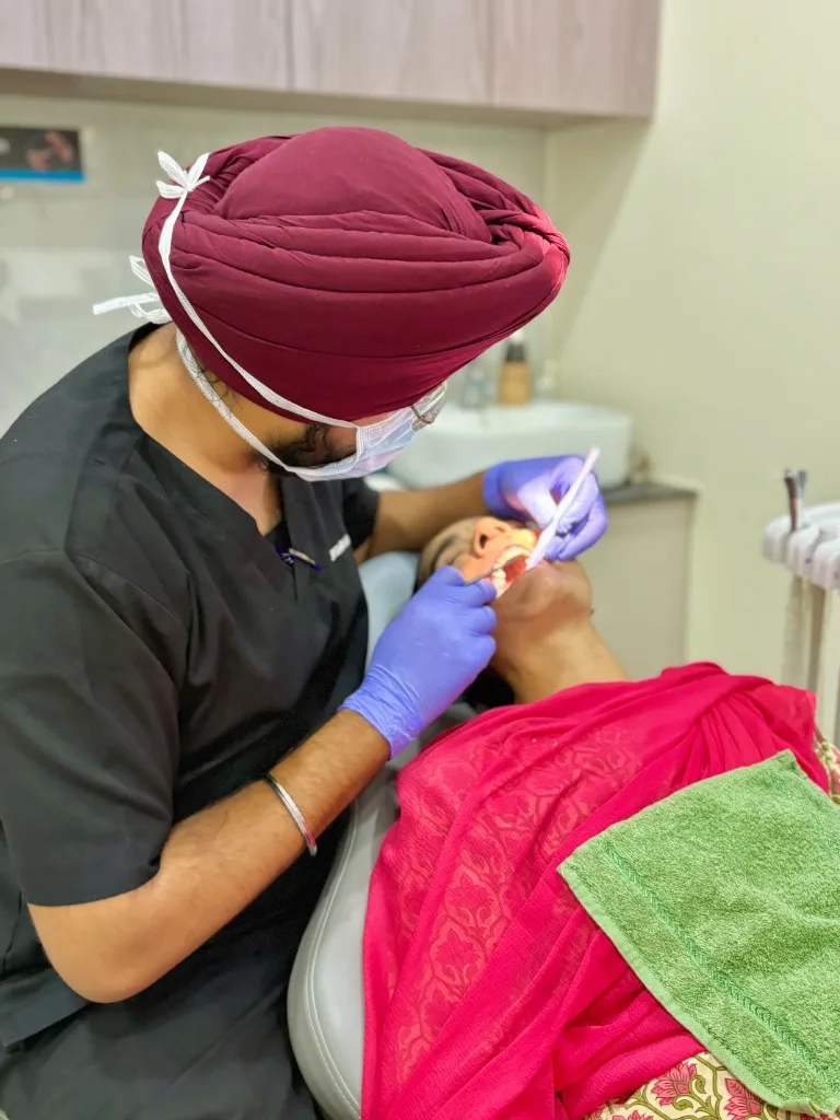 Dr Gursimran Singh Batra performing dental treatment on a patient at Dr Batra's Dental Hub